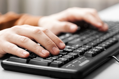 hands typing on a keyboard