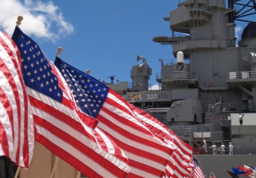 us flags with ship in the background