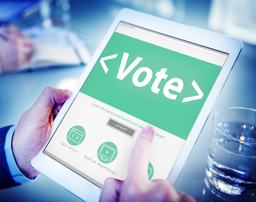 person holding a tablet and placing a vote electronically