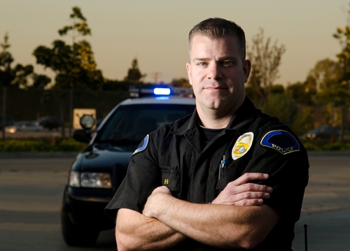 police officer standing in front of a police car