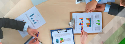 overhead view of people in a meeting looking at financial charts and data