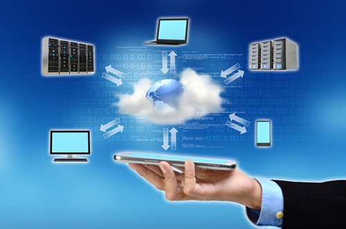 cloud devices surrounding a cloud with arrows and a hand holding a tablet