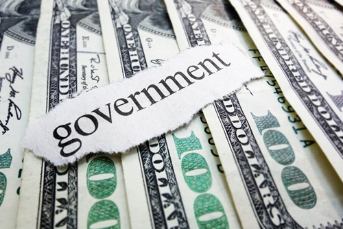 the word government on a piece of paper on top of some dollar bills