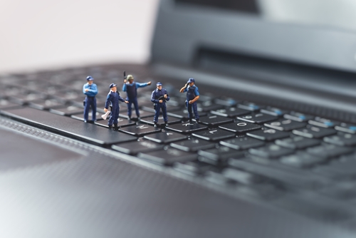 laptop with five small figures on some of the keys