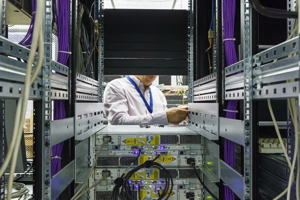 person working on piece of equipment in a server room