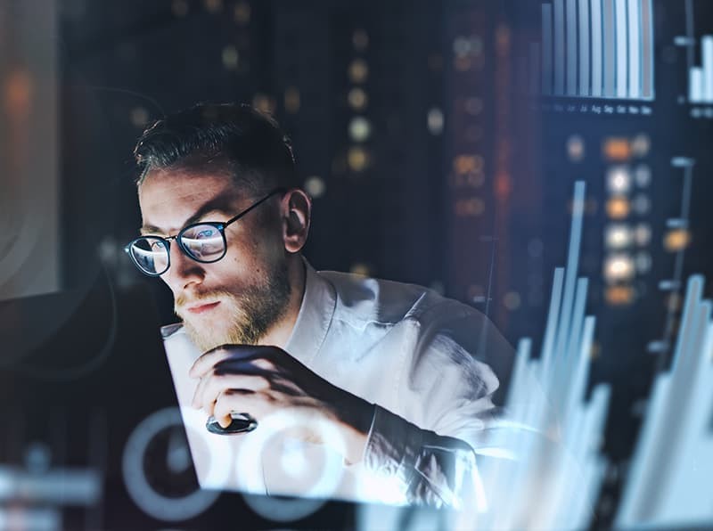 user on a pc looking at code on dual monitors